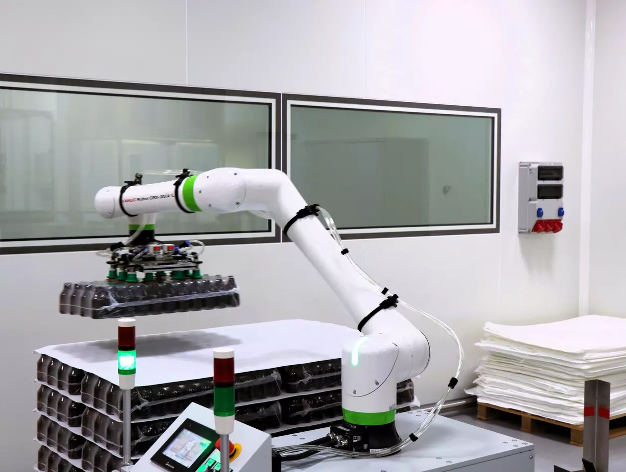 Images case study Phytopharm Klęka S.A from FPL. CRX-20iA/L handles bottle stacks using a custom vacuum gripper, while a CRX-25iA palletises heavy product cartons.
