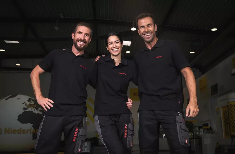 Service team picture with one woman and two men, wearing black FANUC work wear.