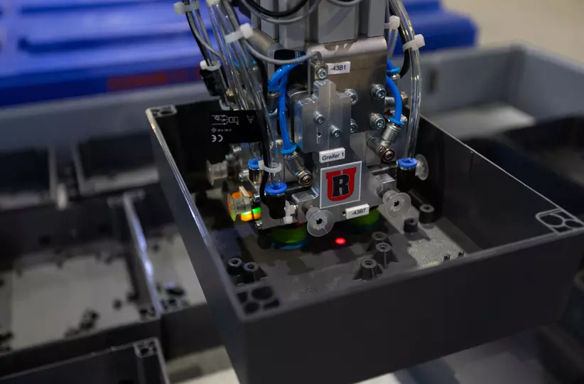 Close‑up of the FANUC robot performing order picking: the advanced end‑effector secures components with precision, enabling seamless integration into the automated assembly process.