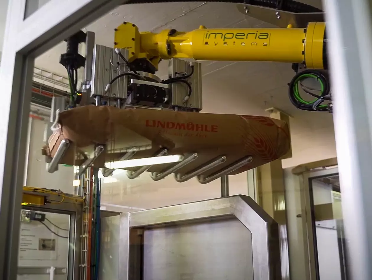 The milling company Lindmühle uses a FANUC M-710iC six-axis articulated arm robot for an automated solution where 5 to 25 kg bags of flour are stacked automatically and each bag is weighed. Not only has the FANUC robot relieved workers at Lindmühle from the physical strain of lifting 5 to 25 kg flour bags onto pallets, but it has also helped the company achieve a 50% increase in its palletising capacity.