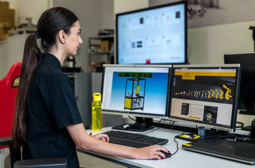 Human resources / apprentice photo with person. Woman at a desk with PC screens. High resolution. Landscape.