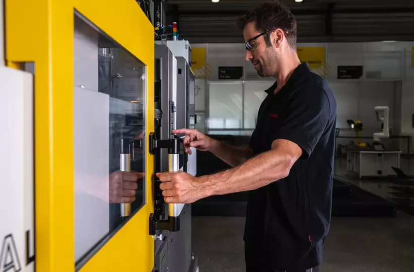 Service / maintenance photo with person. Man checking the inside of a ROBOSHOT machine. High resolution.