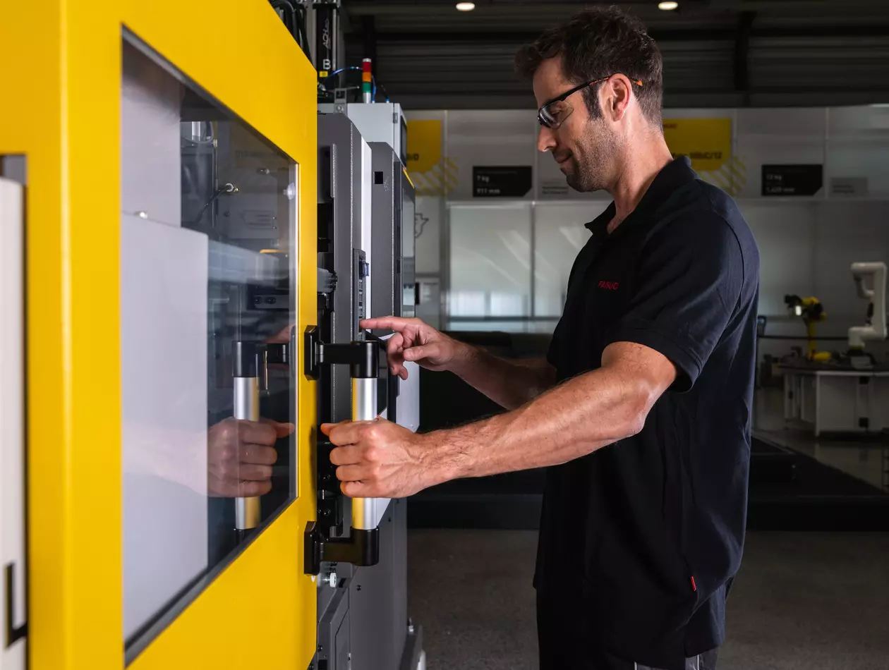 Service / maintenance photo with person. Man checking the inside of a ROBOSHOT machine. High resolution.