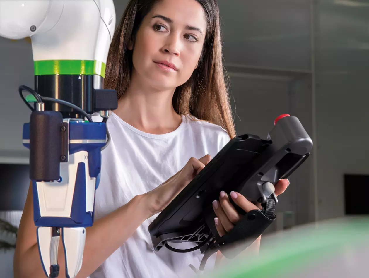 Woman using the Tablet Teach pendant. CRX with iRVision and griper