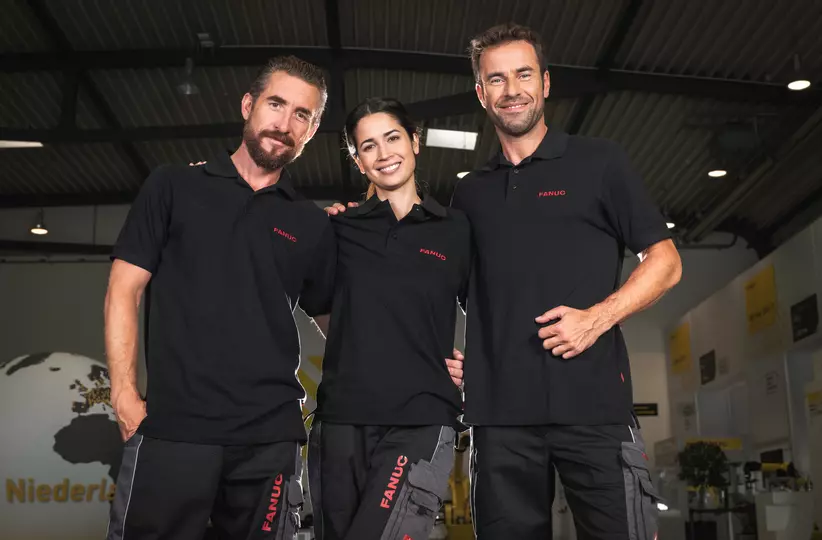 Service team picture with one woman and two men, wearing black FANUC work wear.