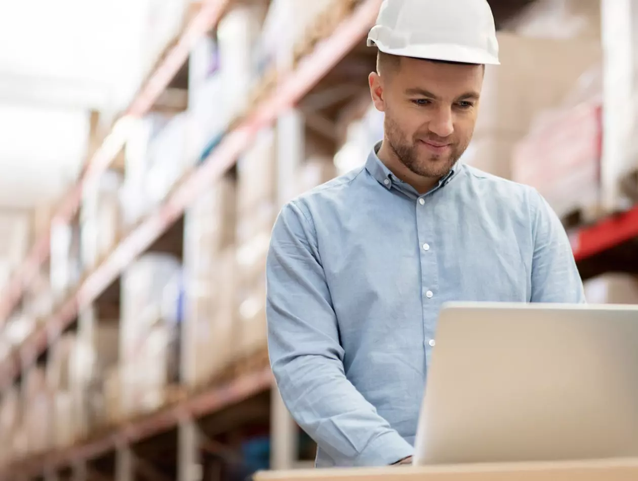 Man working on a laptop in a FANUC warehouse